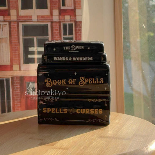 Hocus Pocus stack of books wax melt burner with decorative titles on a wooden surface, with a neutral background.