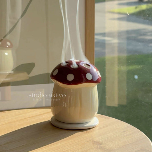 Mushroom-shaped diffuser on a wooden surface with a blurred outdoor background