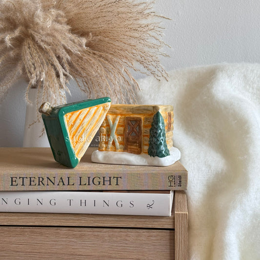 Winter cabin ski chalet wax burner on a stack of books with a soft white background