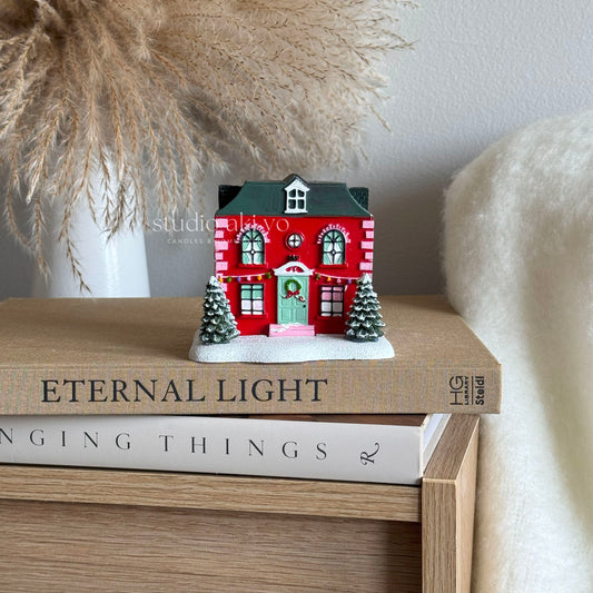 Red Holiday House Incense Cone Holder a stack of books with decorative elements.