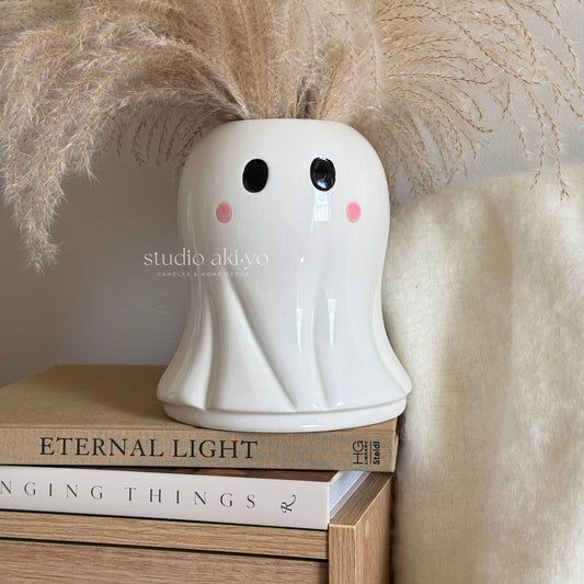 Ghost vase holding dried flowers styled in spooky Halloween décor