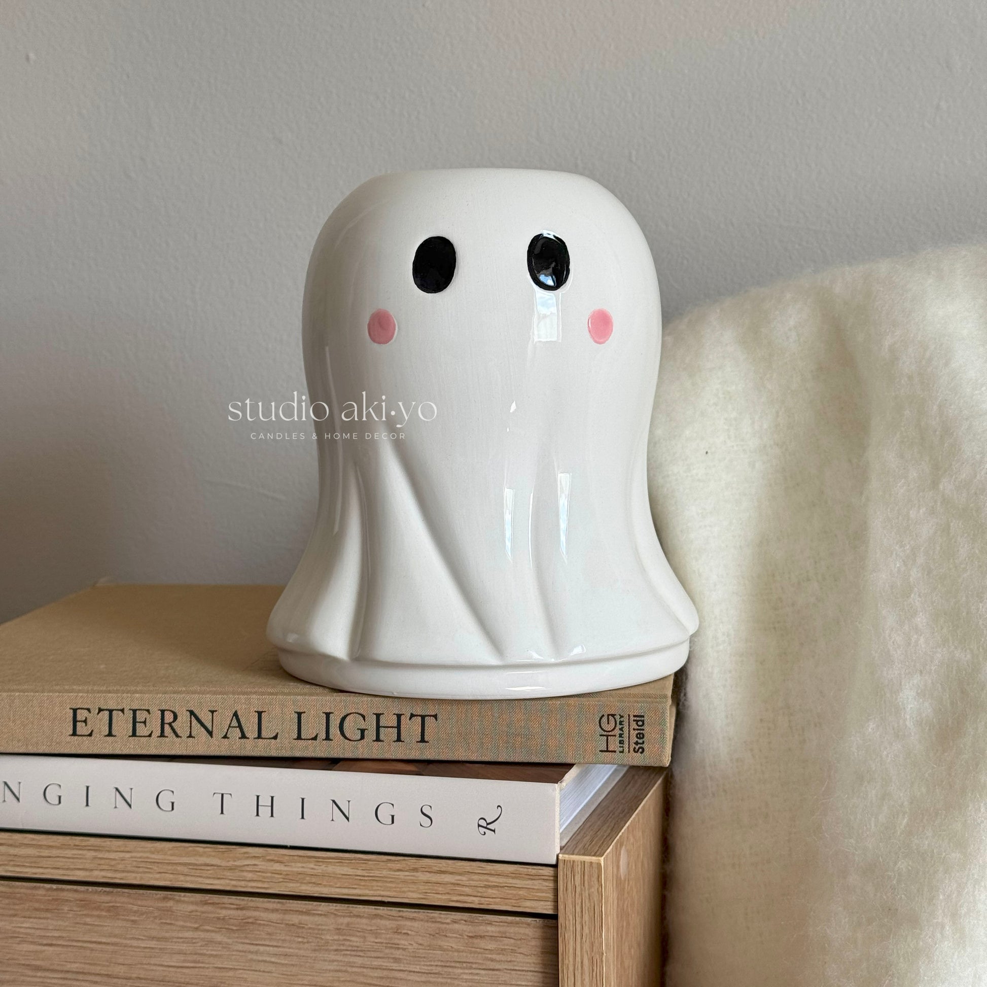 White ceramic ghost flower vase with sculpted eyes for autumn blooms