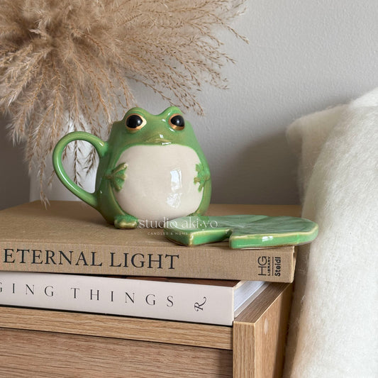 Green cottagecore ceramic frog-shaped mug on matching lily pad coaster