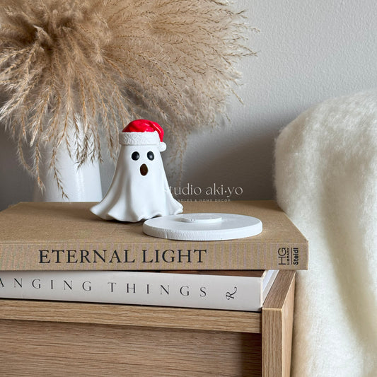 Ghost Santa Hat Incense Cone Holder on books with a neutral background