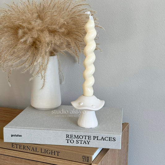 Mushroom candle holder with taper candle on tabletop