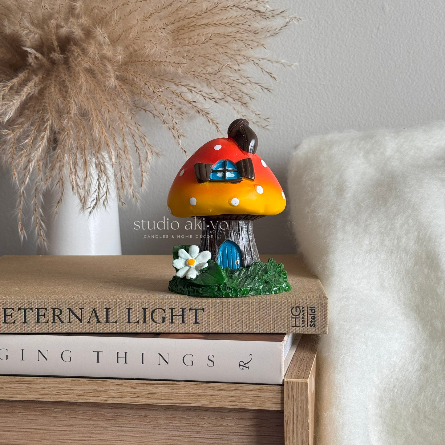 Orange mushroom toadstool incense cone holder on books with a blurred background