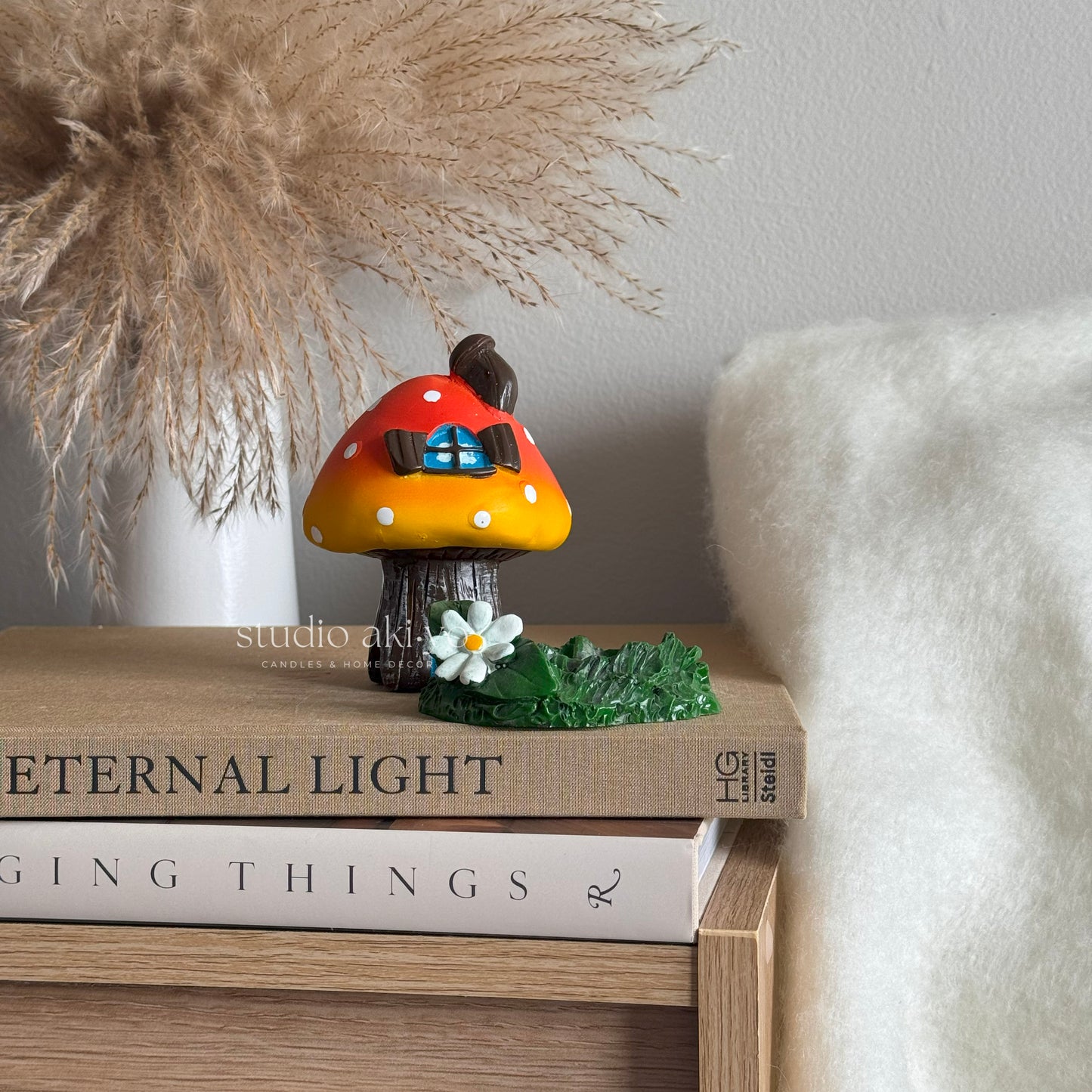 Orange mushroom toadstool incense cone holder on books with a blurred background