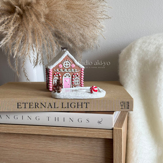 Small gingerbread house figurine on books with decorative background