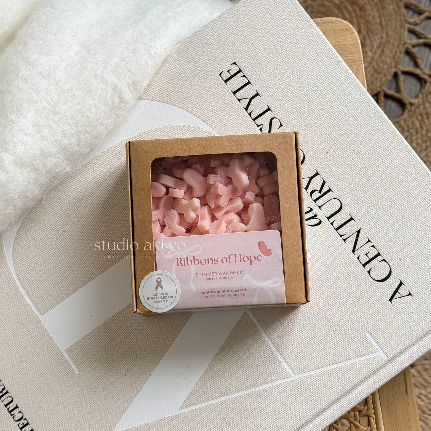 Box of pink wax melts labeled 'Ribbons of Hope' on a textured surface with 'studio artivo' branding.