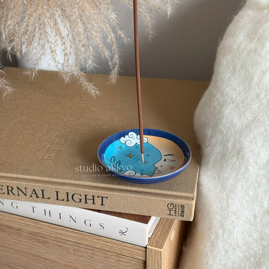 Moon incense stick holder catching ash as incense burns