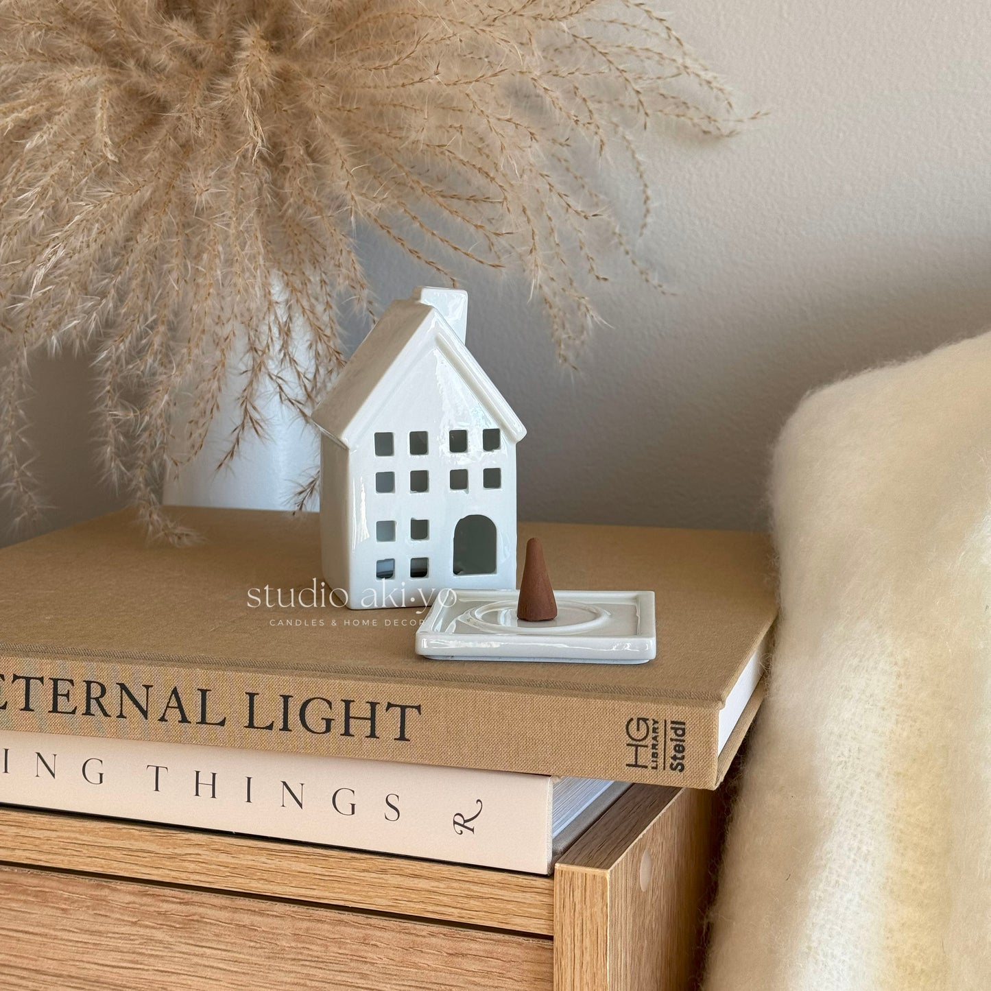 White house incense cone held and ash collecting inside ceramic home