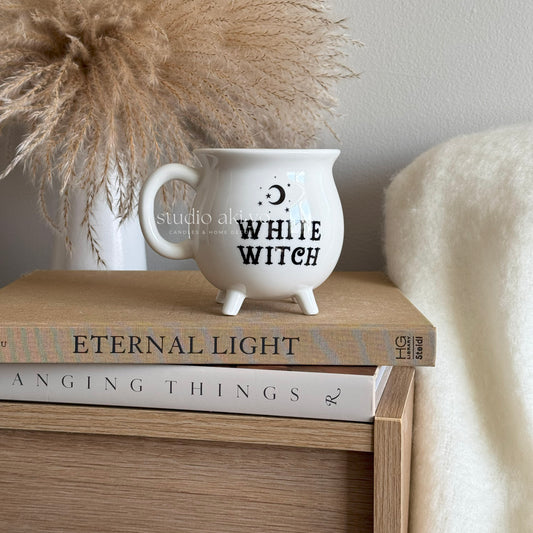 White ceramic mug shaped like a witch's cauldron