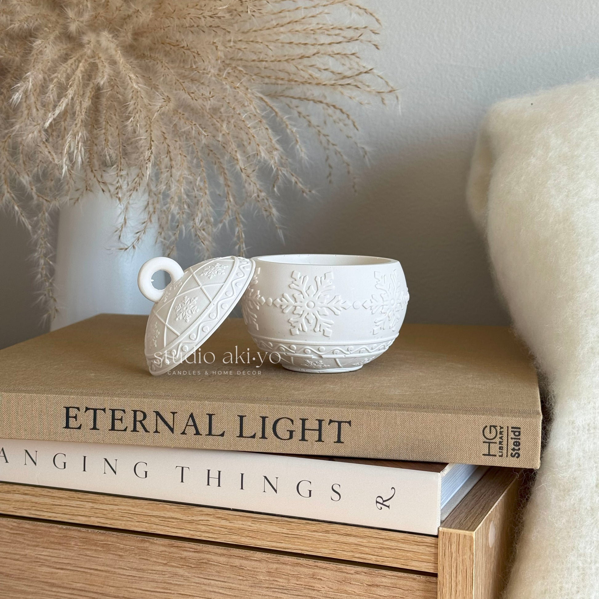 Close-up of handcrafted festive ornament candle jar with winterberry scent