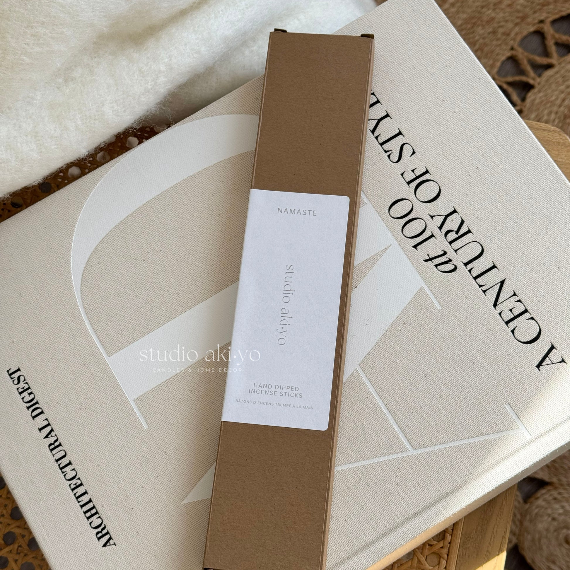 Brown box with a label on top of a book titled 'A Century of Style' by Studio Akiko.