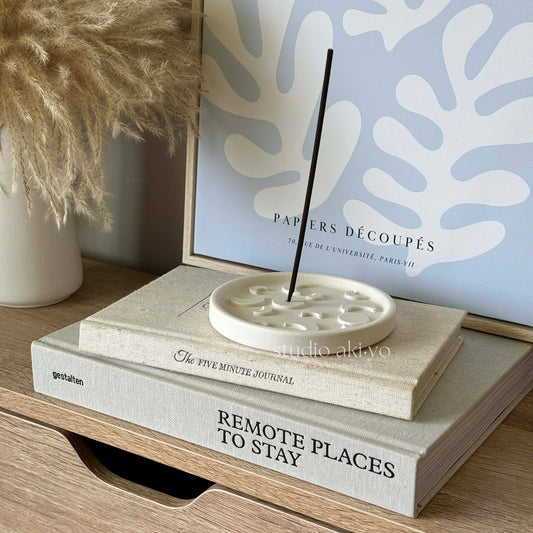 Minimalist incense stick holder with crescent design and burning incense