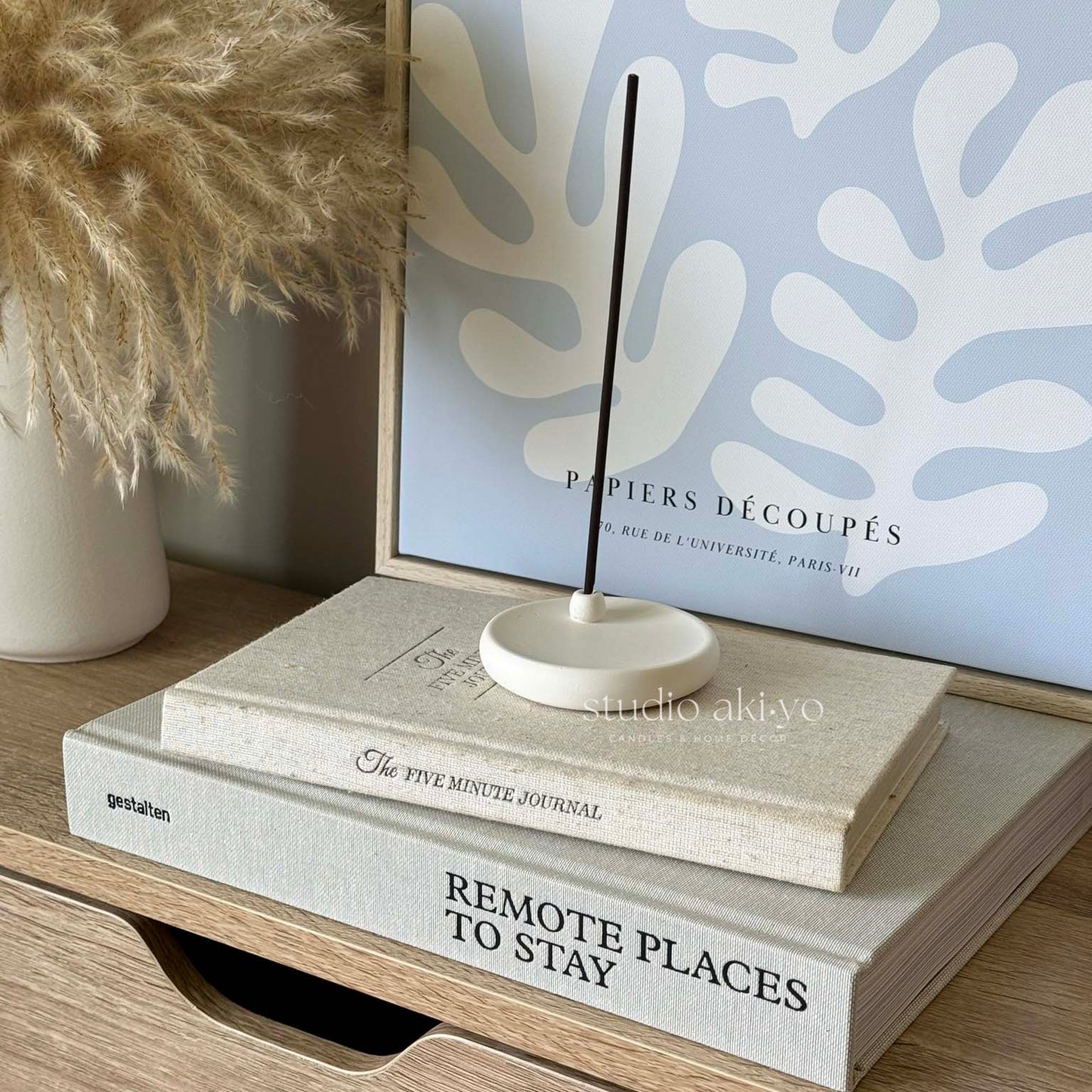 Handmade incense stick holder with lit incense on white background