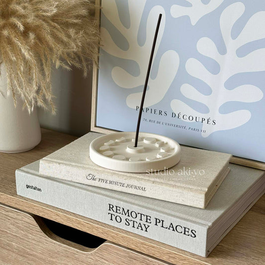 Modern ritual incense holder with lit stick in minimal setting