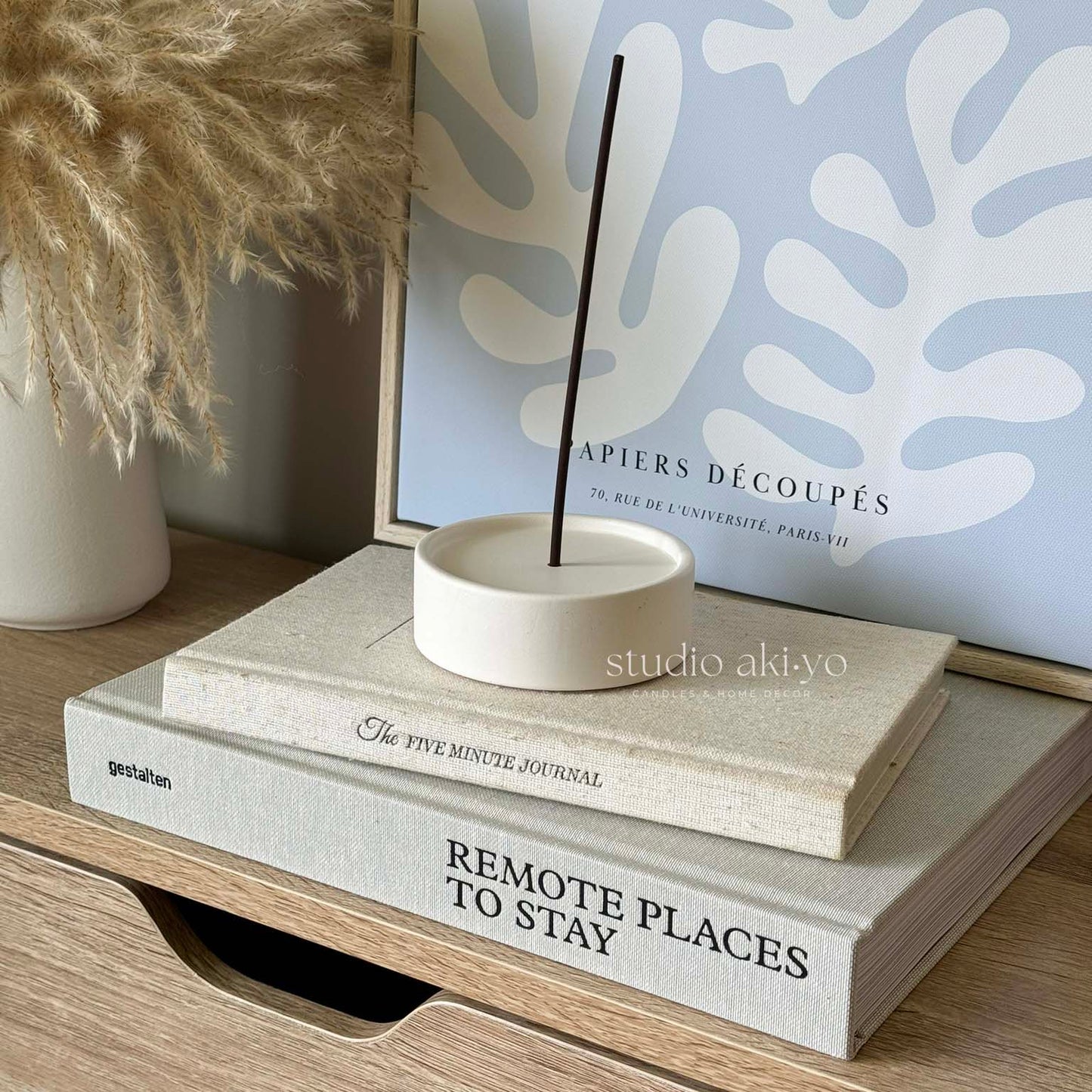 Minimalist round incense burner with lit stick in neutral setting