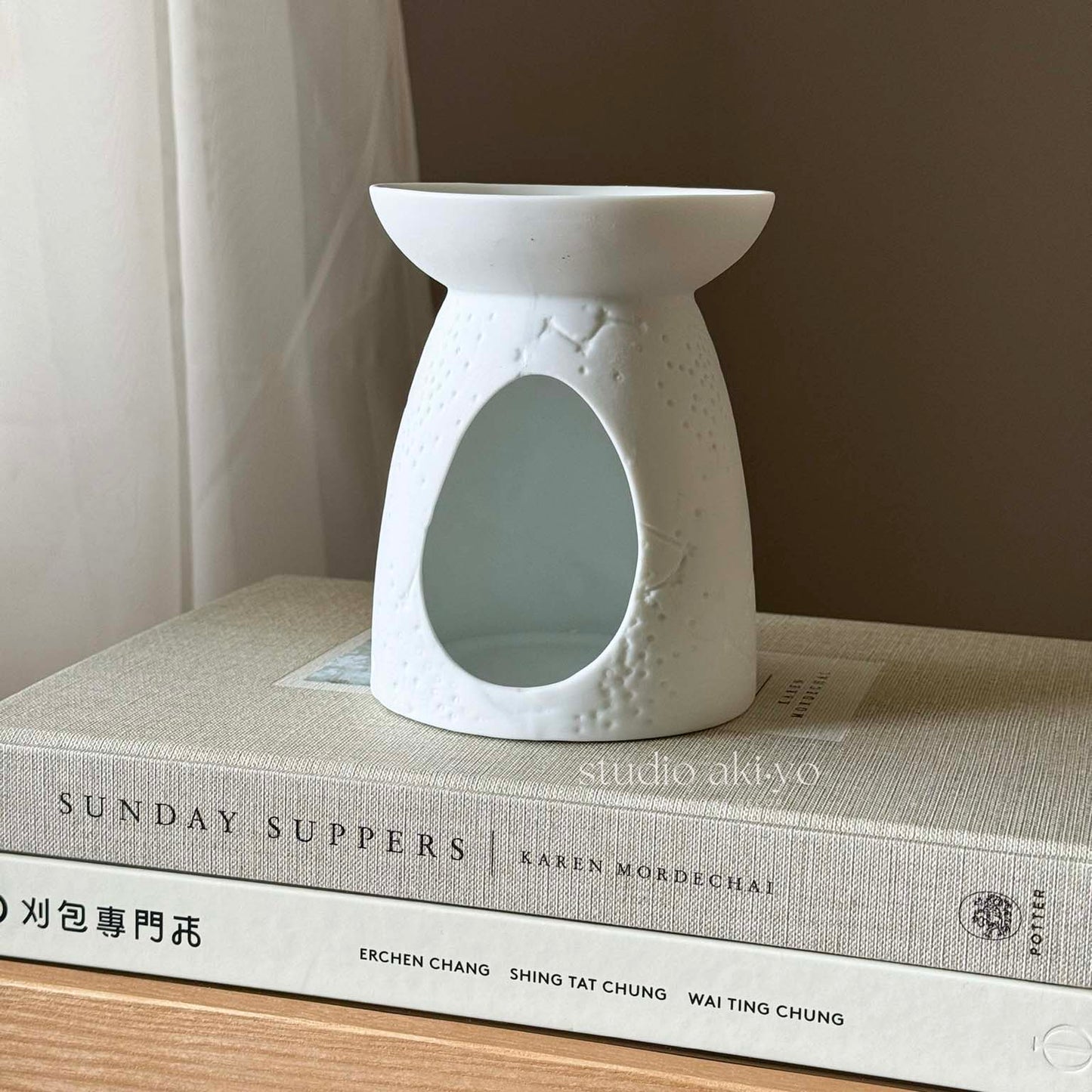 White ceramic constellation wax melt burner with star and moon cutouts and tealight opening