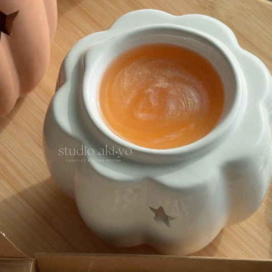 White ceramic pumpkin wax melt burner with star-shaped cutouts for tealight warmth