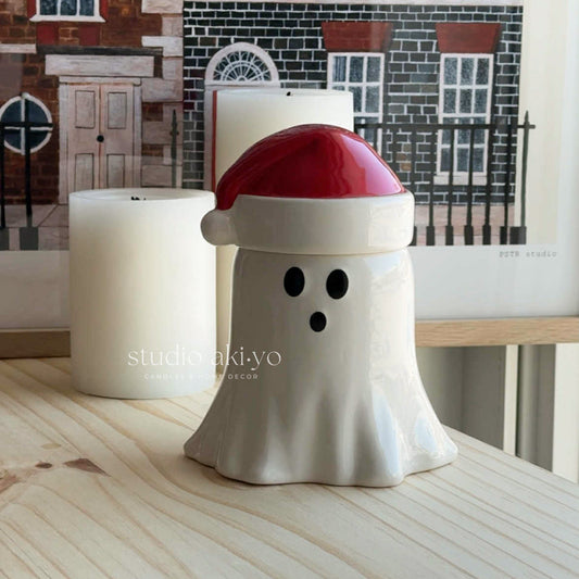 Ghost-shaped candle holder with a red top on a wooden surface, with 'studiotakiyo' branding.