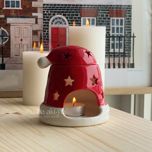 Red ceramic candle holder with star designs on a wooden surface, featuring the brand 'studio aki-yo'.