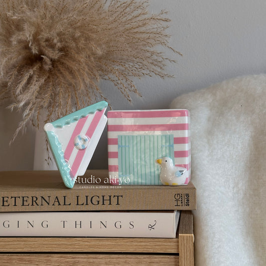 Decorative items including a small box and a duck figurine on books with a neutral background