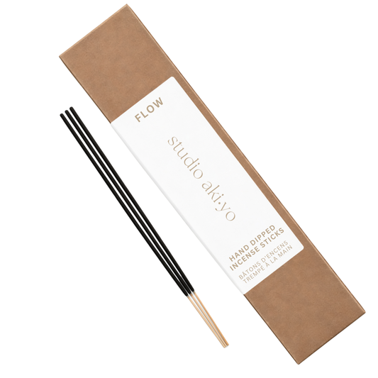 Incense sticks with a brown box labeled 'flow' by studio akiyo on a white background