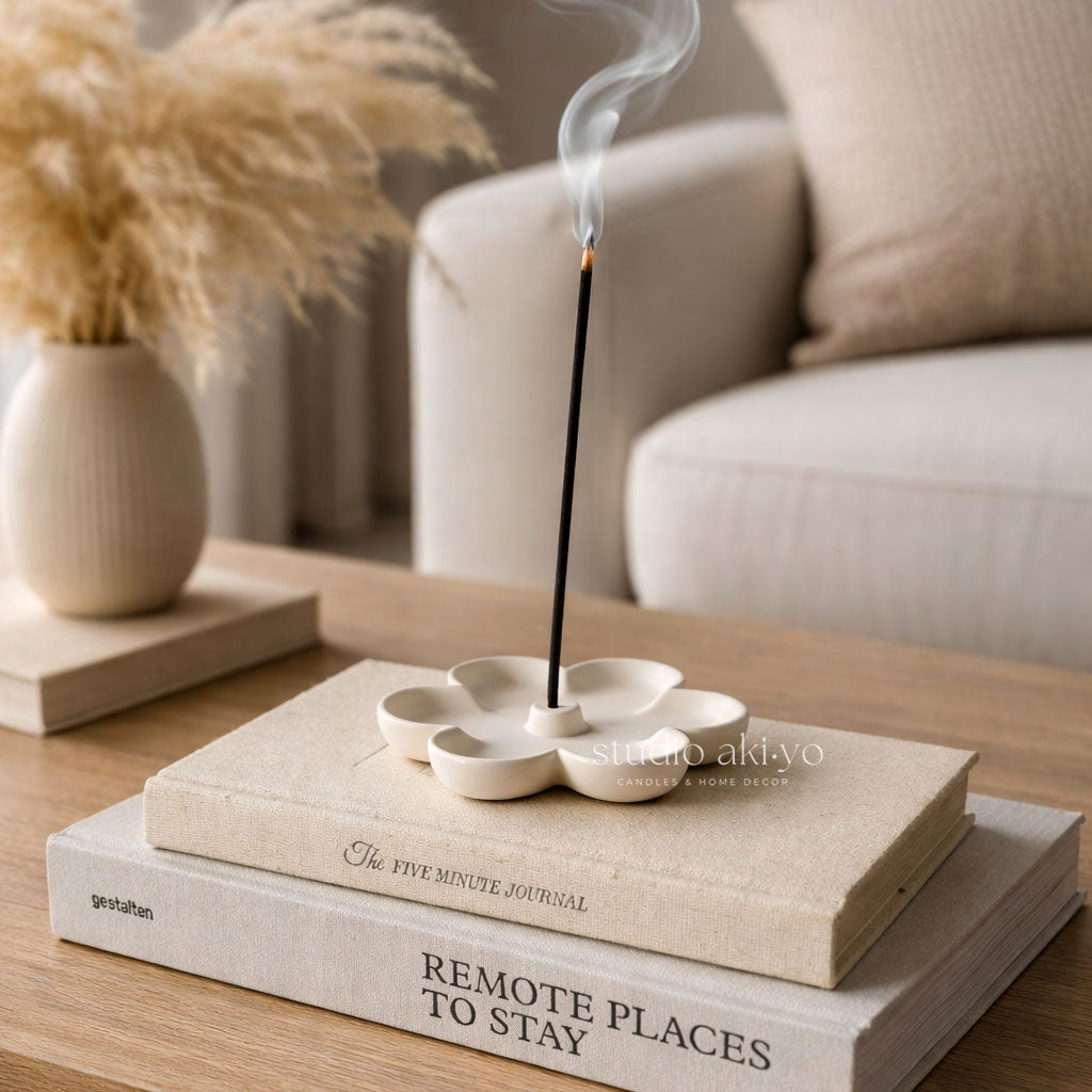 Incense stick burning in a decorative holder on top of books with a blurred background