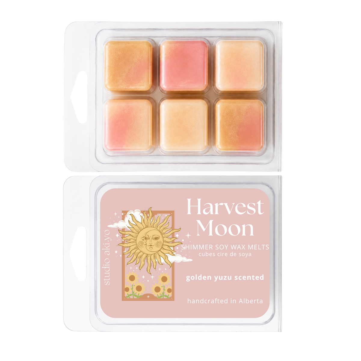 Two clear plastic clamshell packages of Studio Above Harvest Moon soy wax melts, showing six pastel wax cubes in peach, pink, and golden yellow tones, with the back label visible below.