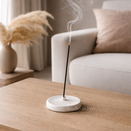 Incense burner with smoke on a wooden table in a cozy living room setting.