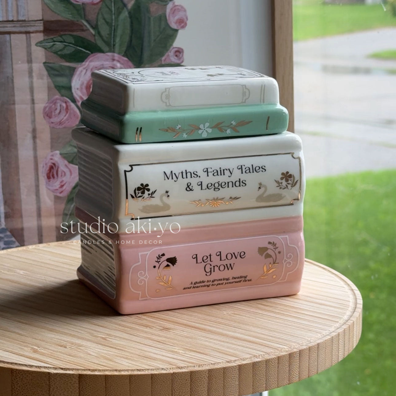 Stack of decorative boxes with text on a wooden surface, featuring the brand 'studio akiyo'.