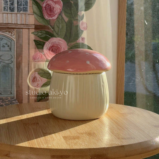 Ceramic mushroom-shaped container on a wooden surface with floral artwork in the background.