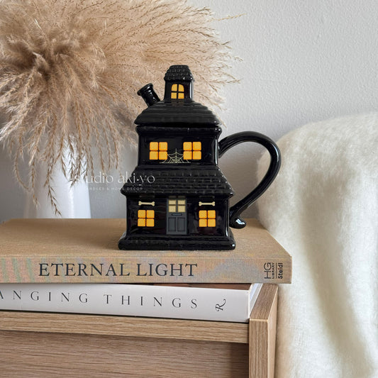 Ceramic mug with haunted house illustration for Halloween