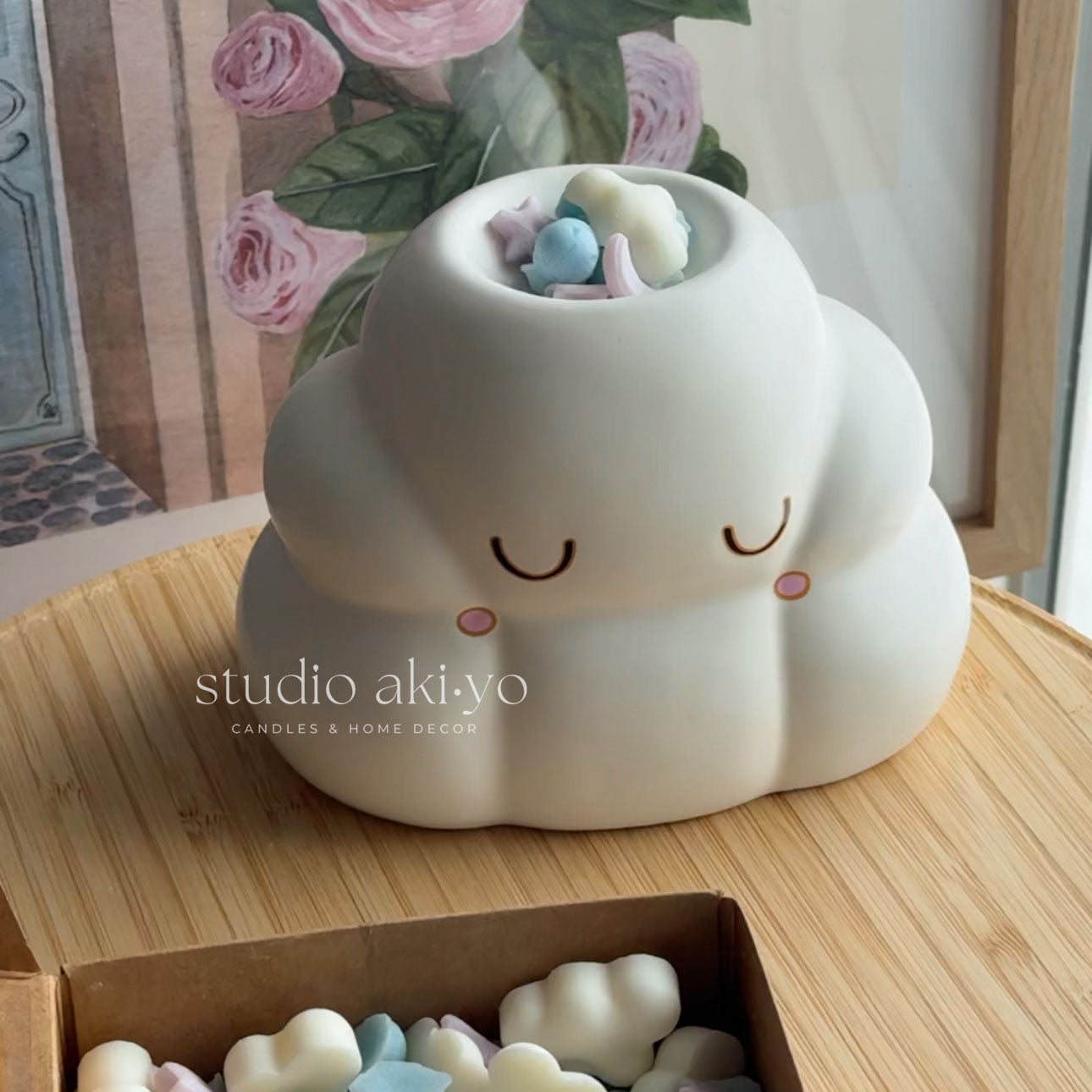 Cute cloud-shaped container with pastel candies on a wooden surface, branded 'studio aki-yo'.