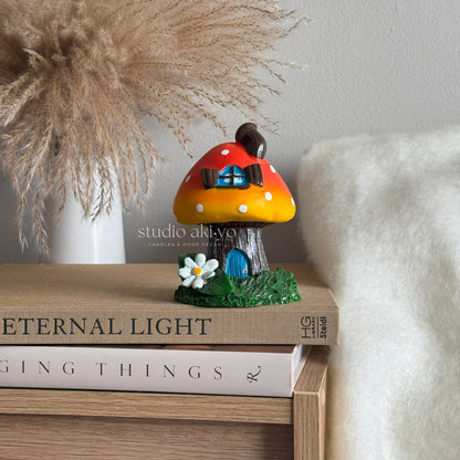 Orange mushroom toadstool incense cone holder on books with a blurred background