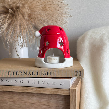 Red ceramic lamp with star design on top of books, featuring 'studio akiyo' branding.