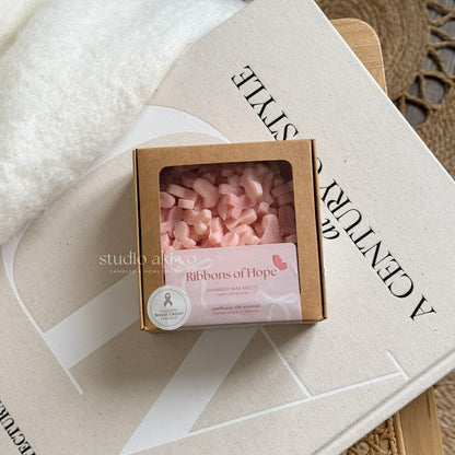Box of pink wax melts labeled 'Ribbons of Hope' on a textured surface with 'studio artivo' branding.