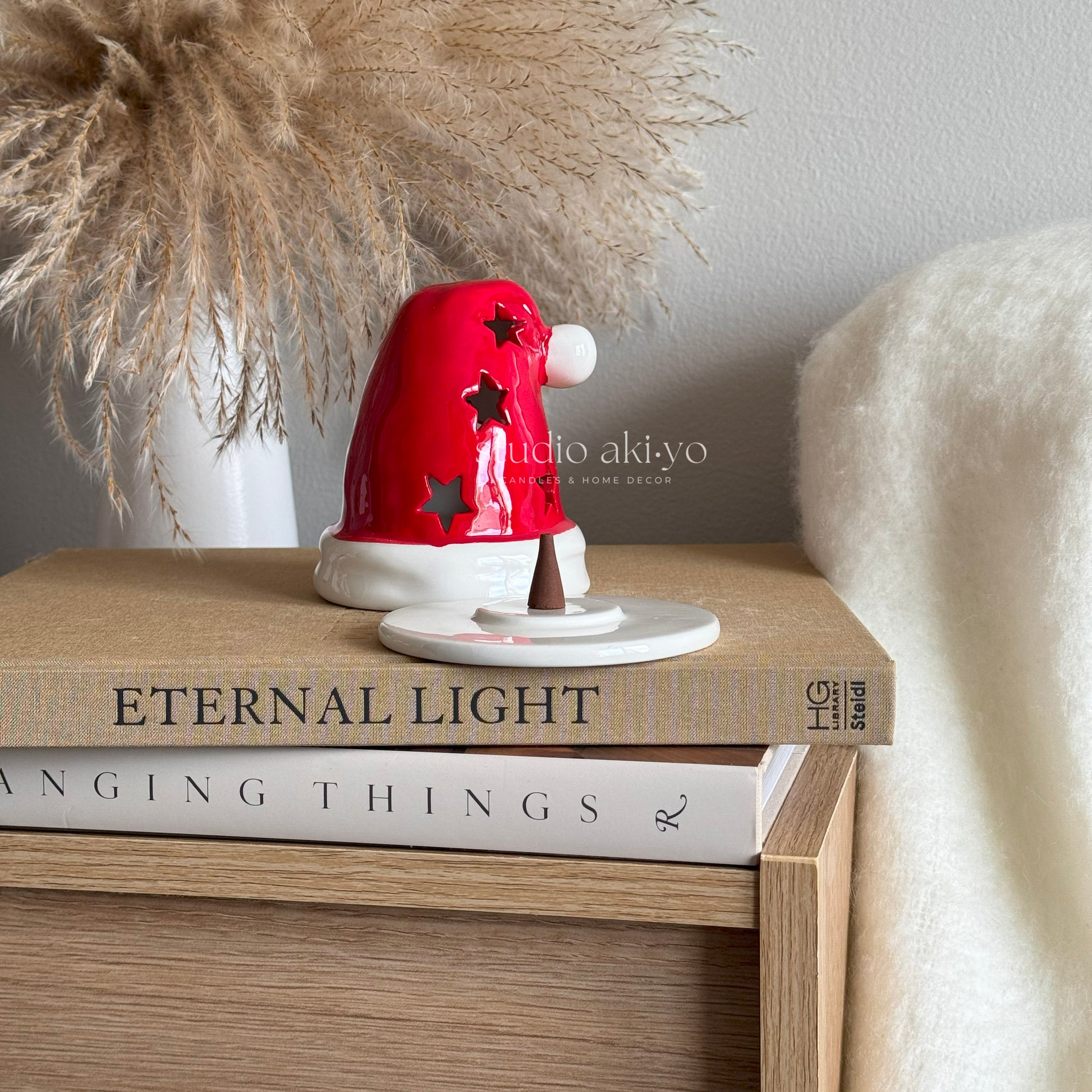 Red and white decorative item on a stack of books with a neutral background