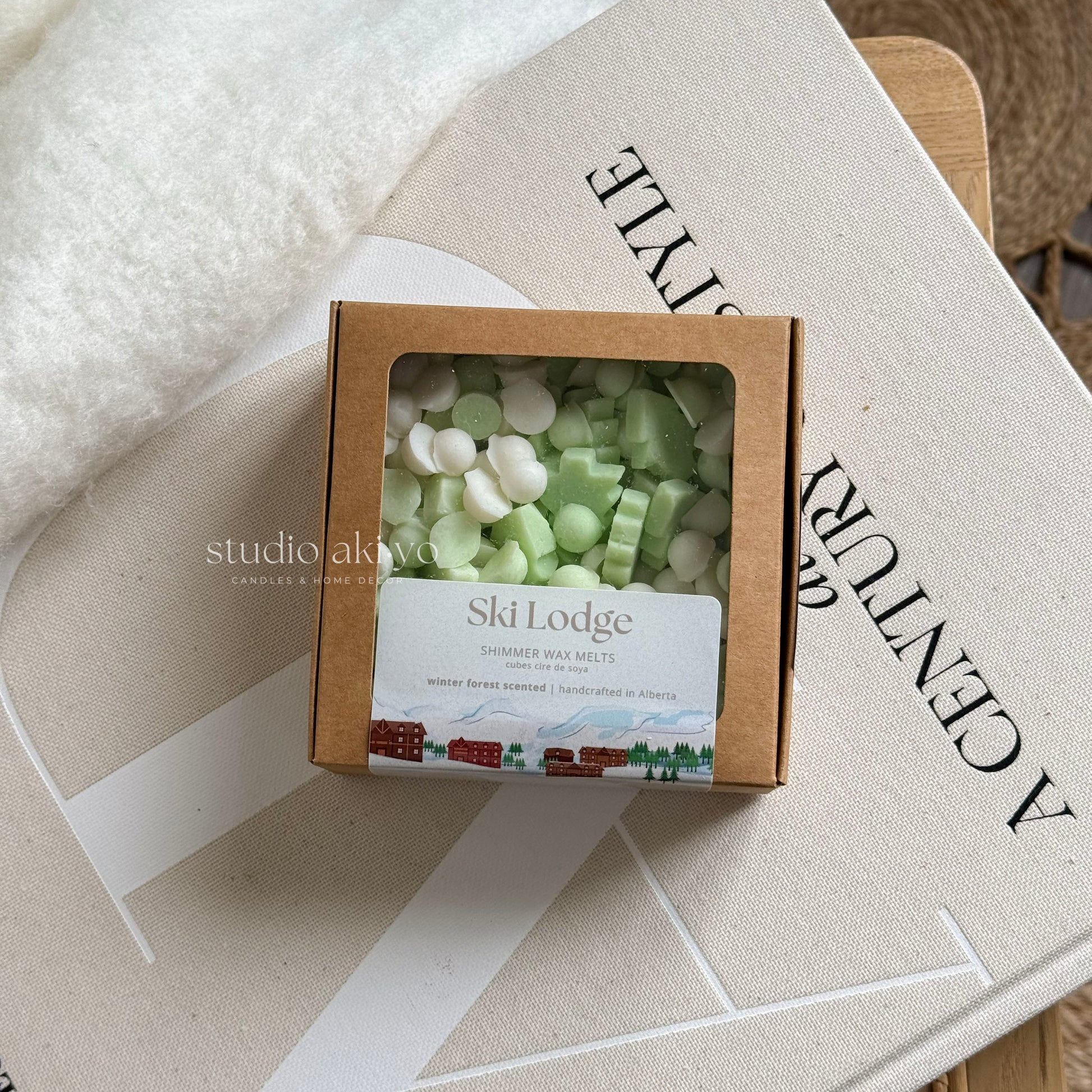 Box of Ski Lodge shimmer wax melts on a textured surface with 'studio akiko' branding.