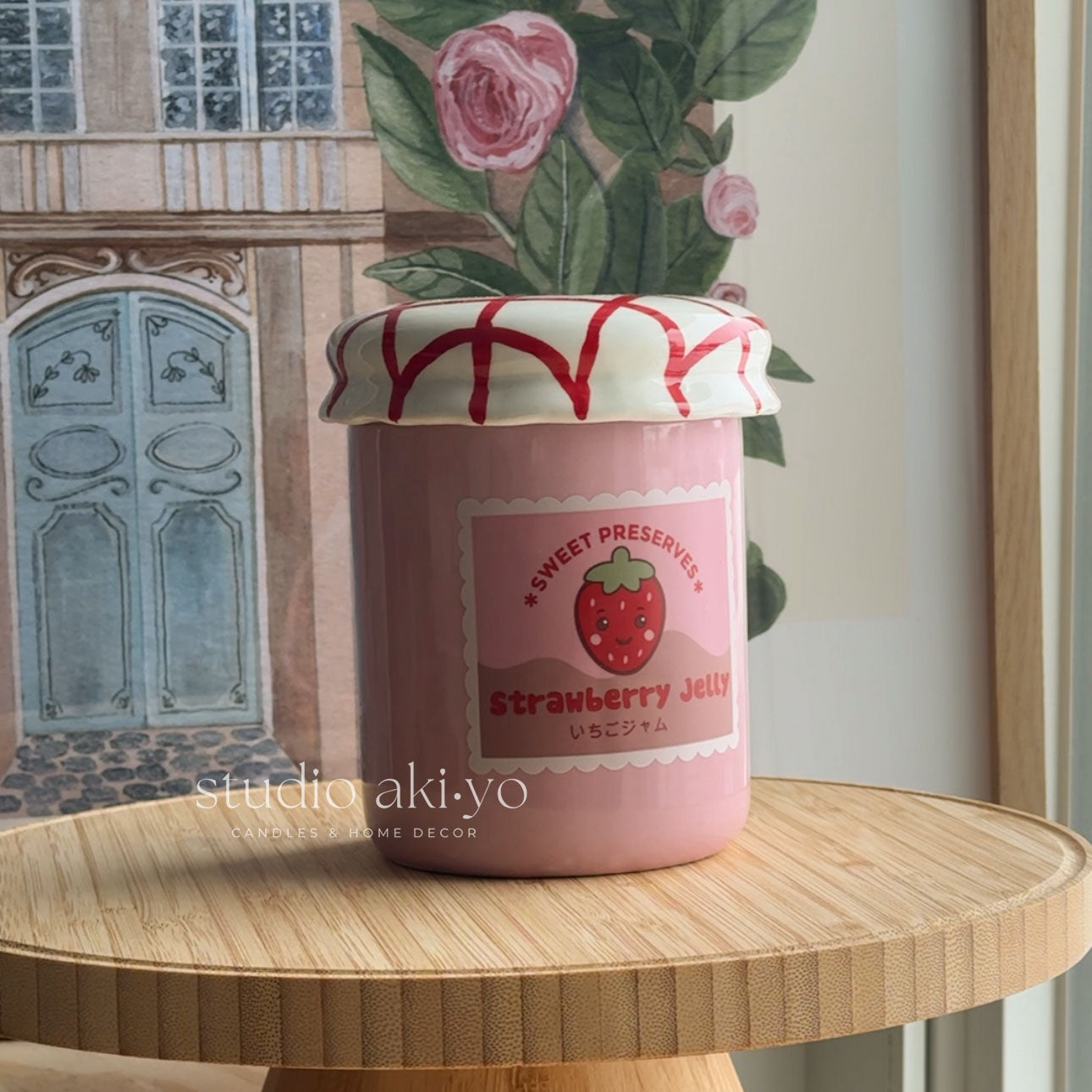 Pink strawberry jelly jar with decorative lid on a wooden surface, featuring 'studio aki-yo' branding.
