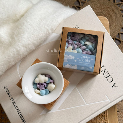 Under the sky wax melt scoopies shaped like a starry skies filled with clouds and stars