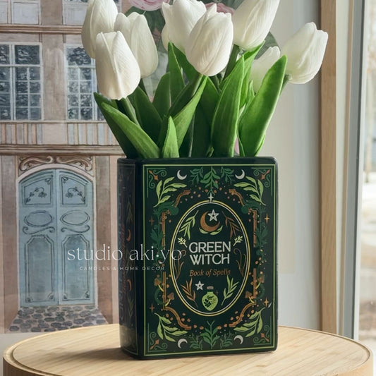Vase with white tulips labeled 'Green Witch' on a wooden surface