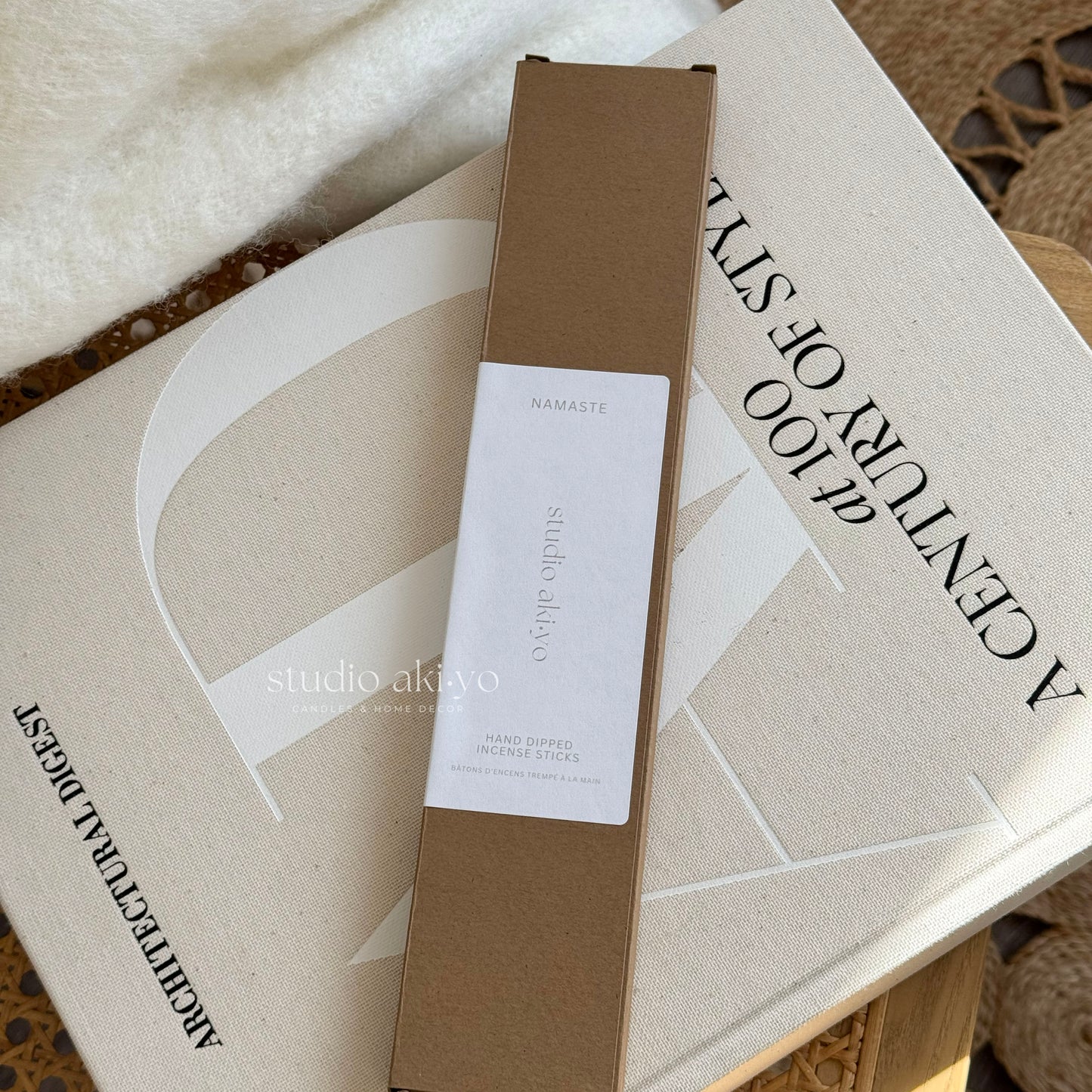 Brown box with a label on top of a book titled 'A Century of Style' by Studio Akiko.