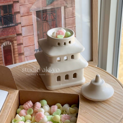 Pagoda wax melt burner with pastel-colored candies on a wooden surface, with 'studio akiyo' branding.