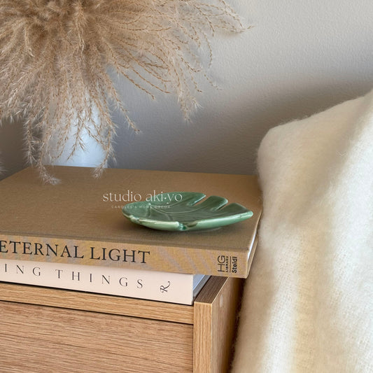 Green ceramic leaf incense stick holder with central hole and ash-catching surface