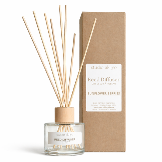 Sunflower Berries Studio Akiyo reed diffuser with wooden sticks and a cardboard box on a white background