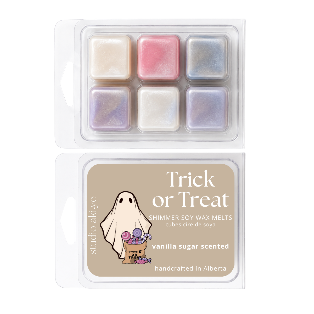 Two clear plastic clamshell packages of Studio Akiyo 'Trick or Treat' shimmer soy wax melts. The top package shows six square wax cubes in pastel shades of cream, pink, and iridescent blue.