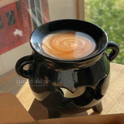 Black ceramic bowl with a swirling design on a surface, with 'studio aki-ya' branding.