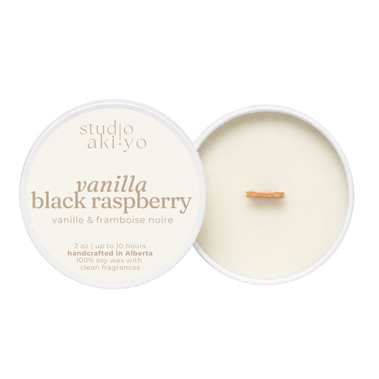 Studio aki-yo Vanilla Black Raspberry soy wax candle shown open with the cream-colored lid on the left and the wax pool and wick on the right, on a solid white background.
